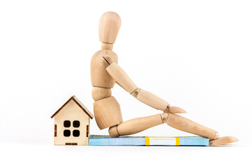 wooden mannequin and house layout, the concept of investing money in real estate