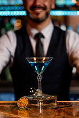Barman is making cocktail at night club.