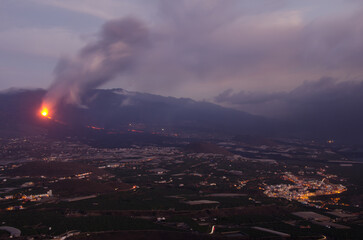 Obraz premium Volcanic eruption of Cumbre Vieja, Aridane Valley and the village of Tazacorte on the right at sunset. La Palma. Canary Islands. Spain.