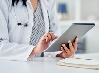 Get medical advice from her anytime. Cropped shot of an unrecognizable doctor using a digital tablet while working in a clinic.