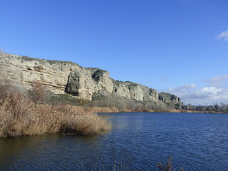 Lagoon with fishermen on a sunny day surrounded by reeds and mountains