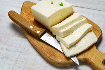 tasty lunch in rural style, healthy food - sliced feta cheese and green leek on a white wooden boards