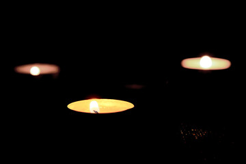 Burning candles on the table in honor of the commemoration in the dark.Burning candles on dark surface.Oppressive atmosphere