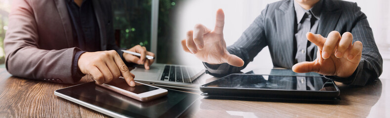 Business partnership coworkers using a tablet to chart company financial statements report and profits work progress and planning in office room.