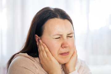 Young woman suffering from tinnitus disease of civilization, healthcare concept