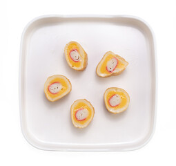 Seasoned minced fish stuffed with Immitation Crab Stick on plate isolated on white background.