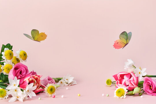 Beautiful spring and summer flowers and butterflies on pink background. Spring Easter or summer holiday background