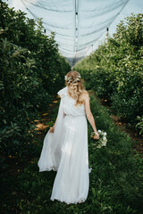 Obraz na płótnie Canvas Lovely bride in a beige wedding dress with a beautiful bouquet of flowers.
