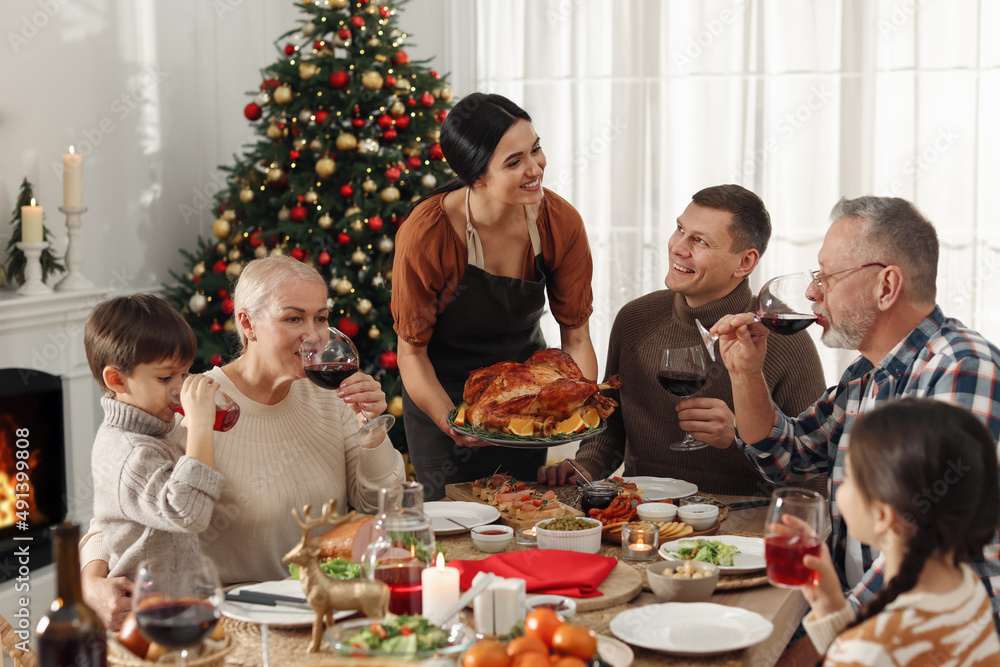 Wall mural Happy family enjoying festive dinner at home. Christmas celebration