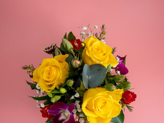Basket of flowers on a pink background. Beautiful bouquet of flowers.