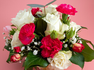 Basket of flowers on a pink background. Beautiful bouquet of flowers.
