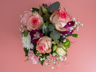 Basket of flowers on a pink background. Beautiful bouquet of flowers.