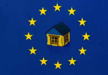 House in the color of the Ukrainian flag on the background of the flag of the European Union (EU). Concept of Ukraine's accession to the EU.