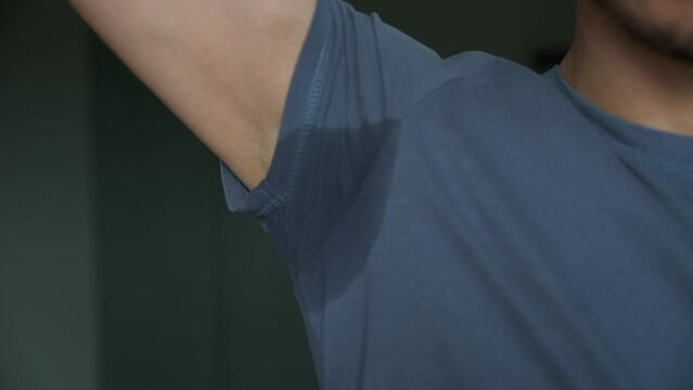 Man in blue t-shirt with sweat stain on armpit, Hyperhidrosis sweating problem