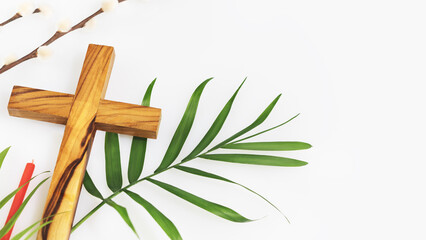 Easter religion composition with wooden crucifixion, palm leaf, willow branch and red church candle...