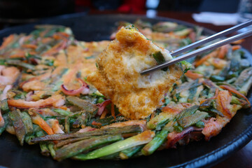 It is a Korean pancake made of seafood and green onions.