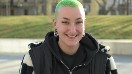 Smiling young woman looking at the camera, positive expression of a lesbian woman laughing, slow motion clip