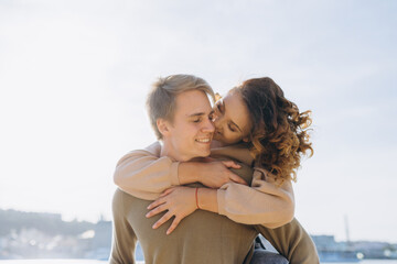 Happy young couple on the beach. The guy holds the girl in his arms, standing on the sand.portrait of a couple in love
