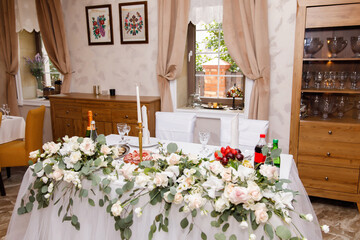 Decorated with flowers and beautifully served honeymoon table in a small vintage restaurant with wooden windows