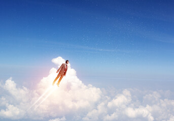 Naklejka premium Businessman in suit and aviator hat flying in sky