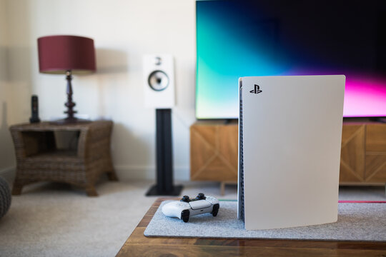 LONDON - MARCH 7, 2022: PlayStation 5 video games console and PS5 controller by living room tv