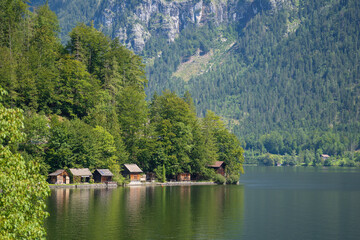 Fototapeta na wymiar Small wooden houses on the lake near Hallstatt mountain village in the Austrian Alps in summer, Austria