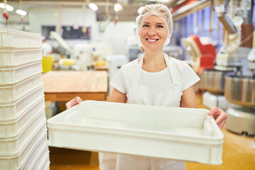 Bäcker Lehrling in der Ausbildung trägt eine leere Kiste