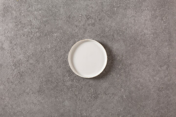 Empty vintage white plate on gray concrete empty background. Food and cooking concept, copy space for text or advertisement