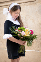 Caucasian little girl with a black and white dress and a colourful bouquet of fresh flowers
