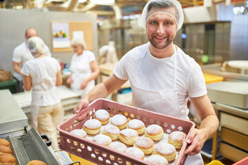 Bäcker Lehrling trägt frische Pfannkuchen in der Bäckerei - obrazy, fototapety, plakaty