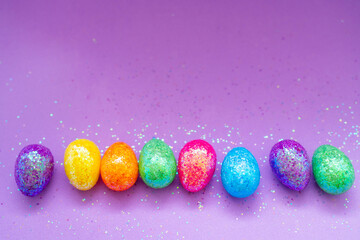 Multi-colored Easter eggs on a purple background. Holiday concept with copy space.