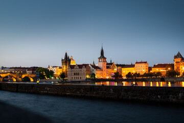 Fototapeta na wymiar perspective to a castle of the night prague at dusk from the side of the Vltava River