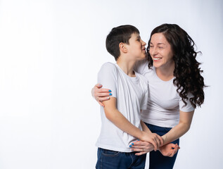 Fototapeta premium mother with son in jeans and white t-shirts on a white background. motherhood concept