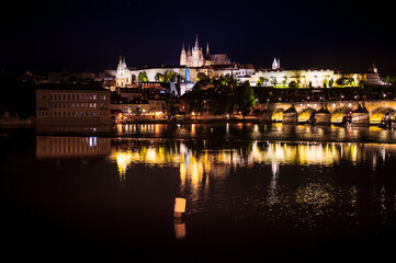 Fototapeta na wymiar perspective to a castle of the night prague at dusk from the side of the Vltava River