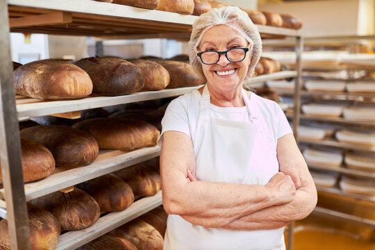 Ältere Frau als Chefin in Bäckerei mit verschränkten Armen