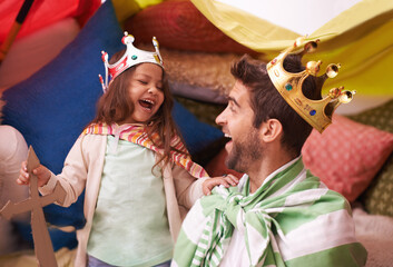 Having so much fun. A cute little girl dressed up as a princess while playing at home with her dad. © T Hover/peopleimages.com