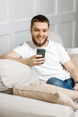 young man at home on the couch talking video call from the phone.