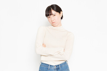 白背景の前に立って怒っているジェスチャーをする女性