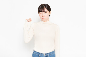 白背景の前に立って怒っているジェスチャーをする女性
