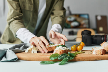 Close up of female food photographer setting up gourmet bruschetta with props in studio, copy space