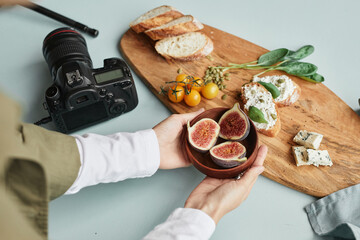 Close up of female food photographer arranging gourmet setup with props in studio, copy space