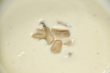 Fototapeta na wymiar creamy soup topping slice champignon mushrooms in bowl
