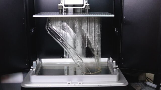 3D Printer Creating the Final Layers for a Car's Full-size Headlight Lens in Clear Resin for the Automotive Industry