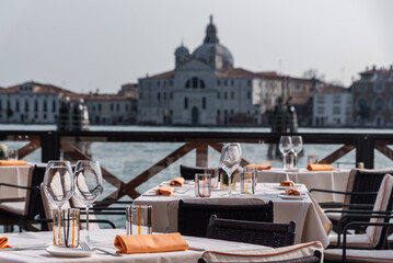 Gedeckter Tisch mit Weingläsern am Canale Grande in Venedig