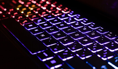 Neon computer keyboard with color backlight. Computer video games, hacking, technology, internet concept.