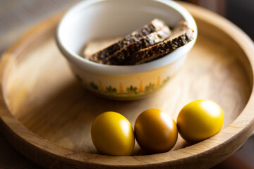 Easter breakfast of colored eggs and grain bread on a beautiful wooden tray
