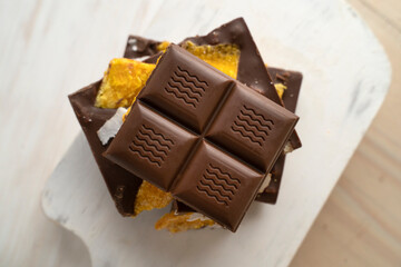 Raw Vegan Handmade Chocolate with dried mango fruits and coconuts slices close up. Chocolate bar with mango on a light background