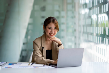 Beautiful Asian business woman working at the office with laptop.