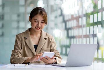 Obraz premium Portrait of a business woman using a calculator This year's bonus calculation Happy working in the office