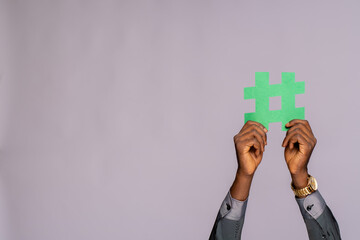 african man holding a hashtag symbol